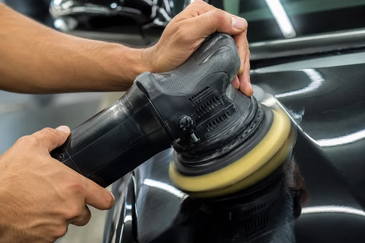 Polimento automotivo sendo realizado em um carro preto